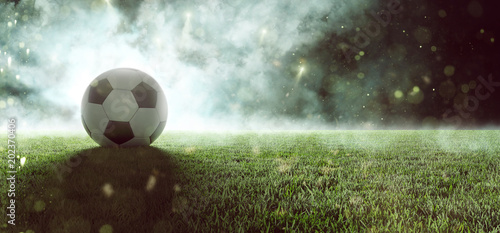 Piłka nożna leży na trawie na stadionie w dymie