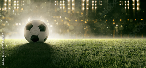 Piłka nożna leży na trawie na stadionie w dymie
