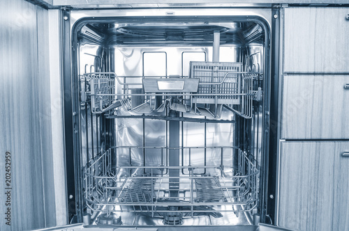 View inside of modern dishwasher machine. Toned image
