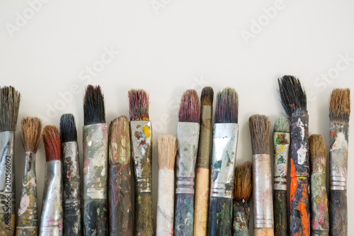 Various dirty paintbrushes arranged in a row