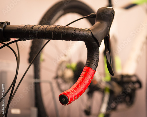 Detail of the red handlebar of a racing bike.