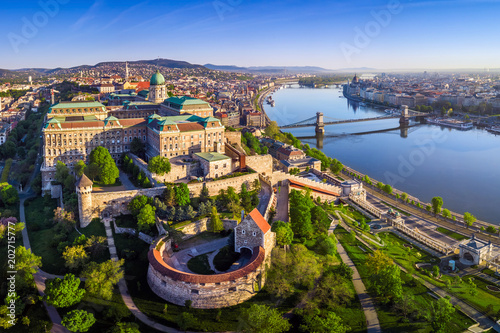 Budapest, Hungary - Aerial panoramic skyline view of Buda Castle Royal Palace with Szechenyi Chain Bridge, Hungarian Parliament and Matthias Church at sunrise with clear blue sky