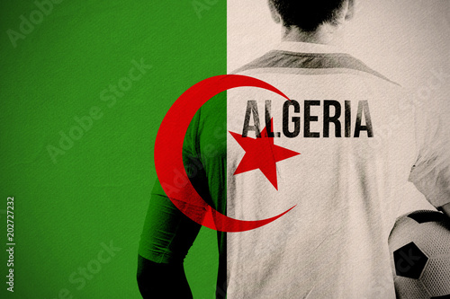 Algeria football player holding ball against algeria national flag