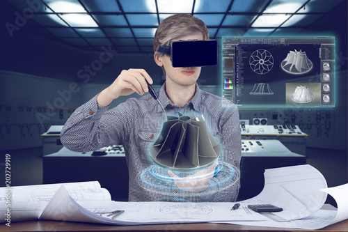 Futuristic cad engineer’s workplace. Male / man wearing shirt and vr glasses touches with screwdriver 3d model of turbine and looking at virtual screen analyzing data for mechanic industry