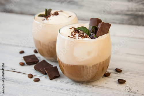 Iced Mocha Coffee with Whip Cream, Summer Drinking times. Coffee Beans. rustic textured Wooden Background. Mint Leaves