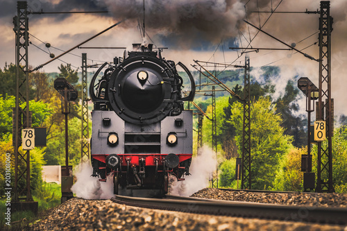 Steam locomotive at full throttle in the countryside