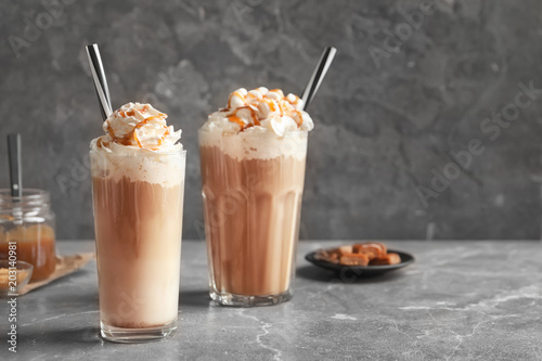 Glasses with delicious caramel frappe on table