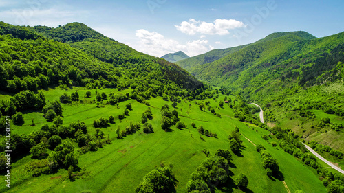 Road between green mountain hills on a fresh spring morning. Carpathian mountains from Romania