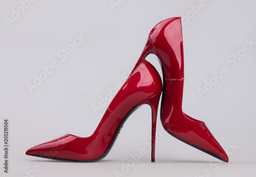 Women's red shoes with a varnish on a gray background