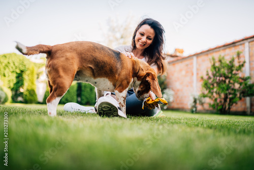 Beautiful smiling woman and her dog in the backyard.