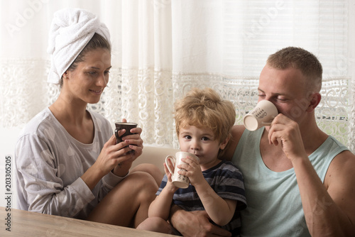 Perfect morning of happy family drinking coffee. Love and trust as family values. Parents with kid on mothers or fathers day. Mother and father with son after shower. Child with father and mother.