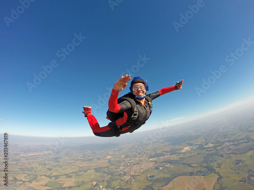 Smiling black woman jumping from parachute