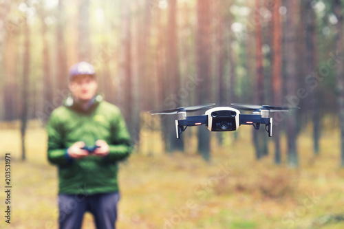 man flying drone in the woods