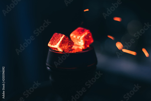 hot red coals for hookah with sparks on dark background close up