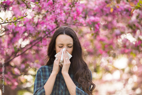 Woman blowing nose because of spring pollen allergy