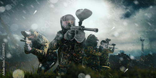 Paintball team in uniform and masks, extreme sport