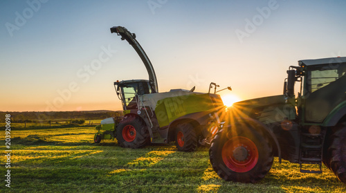 Tractor working agicultural machinery in sunny day