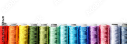 Color sewing threads on white background, top view