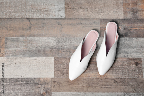 Pair of female shoes on wooden background, top view