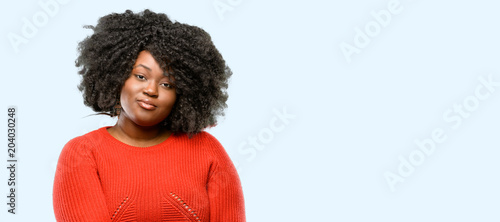 Beautiful african woman confident and happy with a big natural smile laughing, blue background