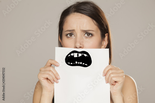 young woman with bad teeth drawn on paper on gray background