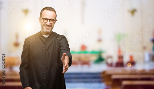 Priest religion man holds hands welcoming in handshake pose, expressing trust and success concept, greeting at church