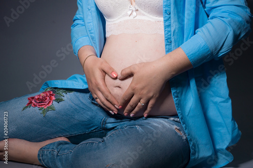 young pregnant woman in anticipation of a child. studio photos on a background. concept of happy motherhood