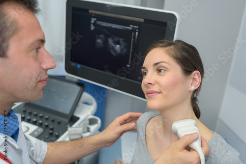 young woman doing neck ultrasound examination at hospital