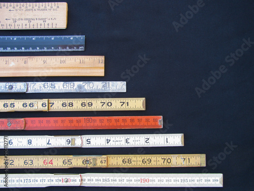 Rulers and scales in metric and inches represent measurement, accuracy and results with copy space. Graphic indicates large numbers at base declining to smaller at top.