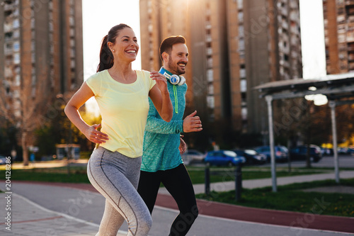 Young attractive couple running outside on sunny day