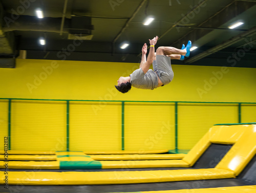 trampoline jumper performs complex acrobatic exercises and somersault on the trampoline.