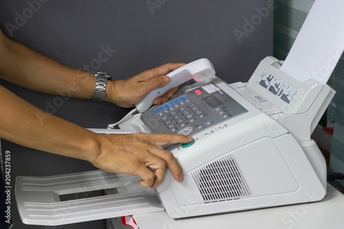 hand man are using a fax machine in the office. Business concept 