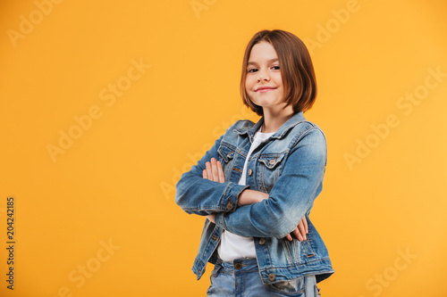 Portrait of a smiling little schoolgirl standing with hands