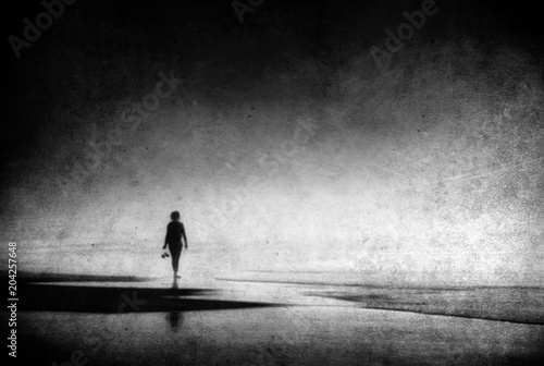 lonely woman walking on beach with grungy textures