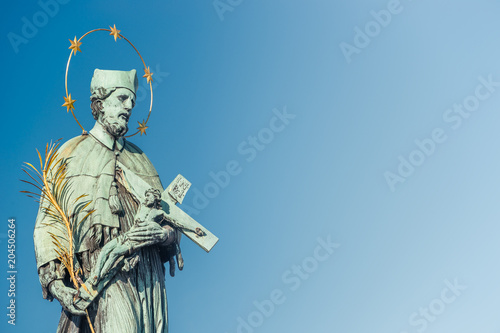 Figure of Saint with cross at Old Town Charles (Karluv most) Bridge Tower in Prague, Czech Republic