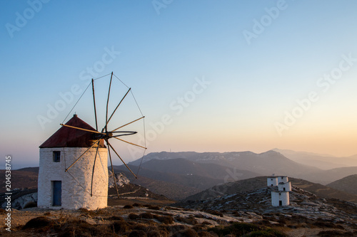 A windmill at the top of the Chora of Amorgos with a series of deserted windmills at the background