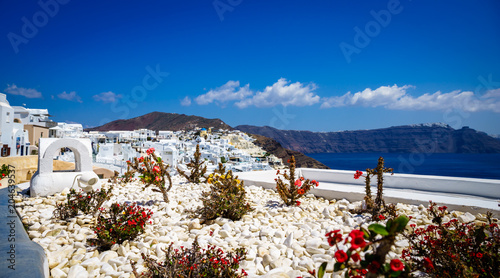 Oia town on Santorini island, Greece. Traditional and famous houses and churches with blue domes over the Caldera, Aegean sea at sunny day