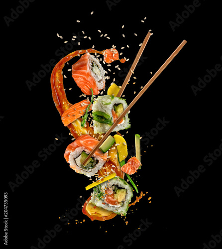 Flying sushi pieces on black background