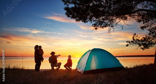 Rodzinny odpoczywać z namiotem w naturze przy zmierzchem
