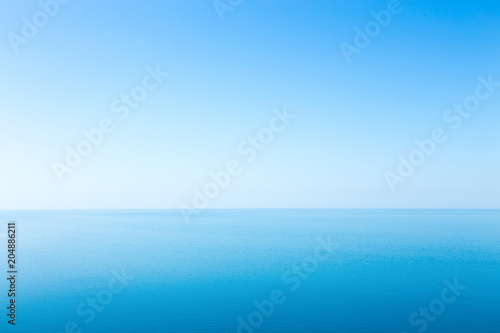 Beautiful seascape without clouds. Perfectly clean smooth sea and clear blue sky