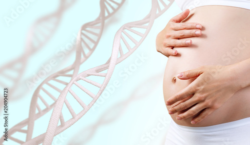 Young pregnant woman caress belly among DNA stem.