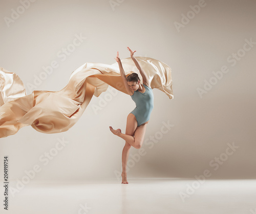 Modern ballet dancer dancing in full body on white studio background.