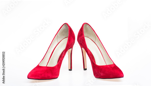 Shoes made out of red suede on white background, isolated. Footwear for women with thin high heels. Elegant stiletto shoes concept. Pair of fashionable high heeled pump shoes.