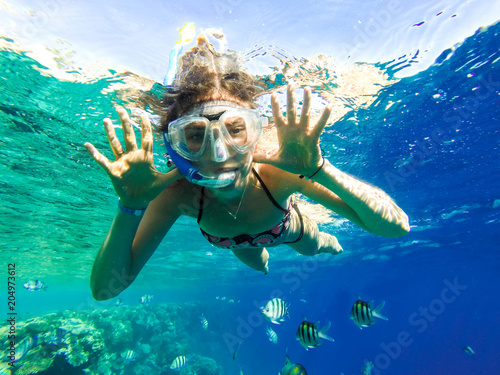 Happy family, girl in snorkeling mask dive underwater with fishes in coral reef sea. Travel lifestyle, water sport outdoor adventure, summer beach holidays with child.