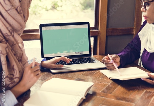 Islamic women discussing and using laptop for working