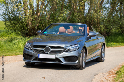 Young woman drive a convertible car on a sunny day