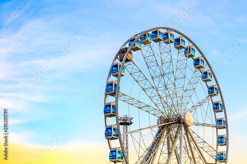 Ferris wheel on colorful sky background.
