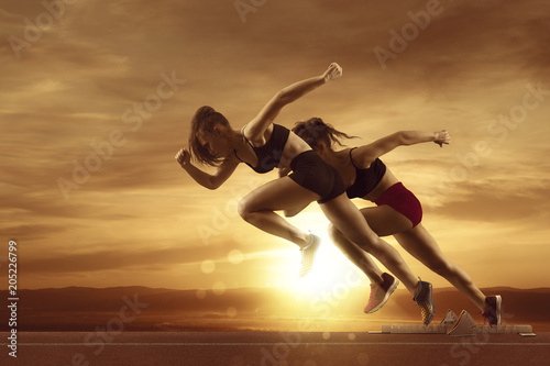 Kobieta sprinter pozostawiając bloki startowe na torze sportowym