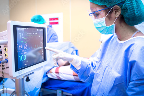 Female surgeon using monitor in operating room.