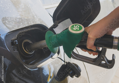 Female hand refueling car at gas station.